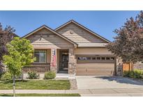 Inviting single-story home showcasing a well-manicured lawn, a two-car garage and attractive stone accents at 25561 E 5Th Pl, Aurora, CO 80018