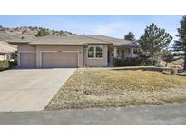 Charming single-story home features a well-manicured lawn and three-car garage at 6960 Choke Cherry Way, Littleton, CO 80125