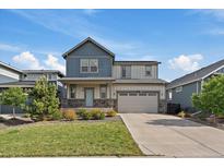 Charming two-story home with a well-manicured lawn, beautiful landscaping, and a two-car garage at 26789 E Cedar Ave, Aurora, CO 80018