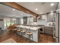 Modern kitchen featuring a large island, stainless steel appliances, and an open layout connecting to the dining area at 9325 Lark Sparrow Dr, Highlands Ranch, CO 80126