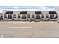 Charming row of white-painted townhomes, each with a black awning, offering an appealing street view at 120 W Bayaud Ave, Denver, CO 80223