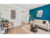Cozy living room with a stylish sofa, a decorative rug, and an eye-catching blue accent wall at 120 W Bayaud Ave, Denver, CO 80223