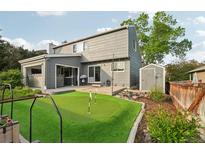 Captivating backyard with a putting green, patio, and shed, all beautifully framed by mature trees and meticulous landscaping at 6307 Monterey Pl, Highlands Ranch, CO 80130