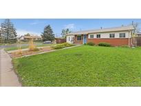 Quaint single-story home with brick and siding, featuring a lush green lawn and tidy landscaping in a residential neighborhood at 3100 W 94Th Ave, Westminster, CO 80031