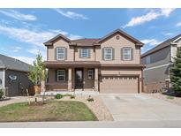 Charming two-story home with a well-manicured lawn, covered porch, and attached two-car garage at 7315 Blue Water Dr, Castle Rock, CO 80108