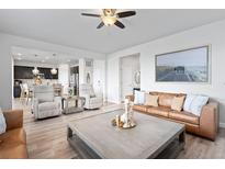 Bright living room featuring hardwood floors, a ceiling fan, a leather couch and contemporary furnishings at 7315 Blue Water Dr, Castle Rock, CO 80108