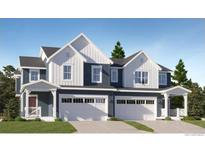 Charming townhome with white and gray exterior, two-car garage, and well-manicured lawn at 577 Nightsky St, Erie, CO 80516