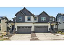 Modern townhome featuring attached garages and covered entrance at 577 Nightsky St, Erie, CO 80516