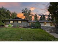 Charming brick home featuring a manicured lawn, mature trees, and a spacious two-car garage at 6392 S Lafayette St, Centennial, CO 80121