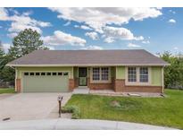 Charming home with an attached two-car garage and well-maintained lawn at 7715 Estes Ct, Arvada, CO 80005