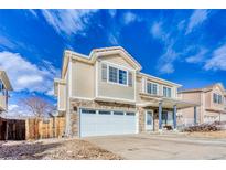 Inviting two-story home featuring stone accents, a two-car garage, and a charming front porch at 15333 E 98Th Pl, Commerce City, CO 80022