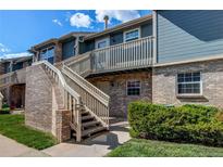 Inviting two-story townhome with brick and wood facade, complemented by well-maintained landscaping at 2690 E Otero Pl # 7, Centennial, CO 80122