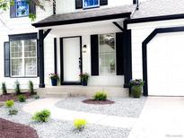 Charming home entrance with manicured landscaping, black shutters, and a bright white front door at 19545 E Bates Ave, Aurora, CO 80013