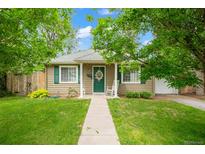 Charming home with a well-manicured front yard, walkway, and cozy rocking chair on the porch at 1221 Ulster St, Denver, CO 80220