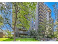 Brick building features a well-maintained lawn, mature trees, and private balconies on each floor at 460 S Marion Pkwy # 102, Denver, CO 80209