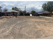 Large gravel backyard with a chain link fence, shed, and detached garage at 6441 Niagara St, Commerce City, CO 80022