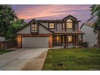 Charming two-story home boasts a well-manicured lawn, brick accents, and an attached two-car garage at 17548 E Wesley Pl, Aurora, CO 80013