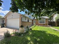 Charming home with a brick facade, attached two-car garage, and a well-manicured lawn at 45 Pierce St, Lakewood, CO 80226