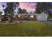 Charming brick home with an attached garage, mature trees, and a well-maintained front yard at 334 S Revere St, Aurora, CO 80012