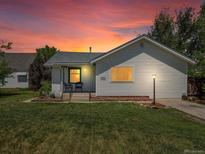 Charming single-story home with a well-maintained lawn and inviting front porch under a lovely sunset at 6801 W 52Nd Ave, Arvada, CO 80002