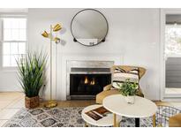 Cozy living room featuring a fireplace, stylish decor, and ample natural light from a window at 11109 Alcott St # D, Westminster, CO 80234