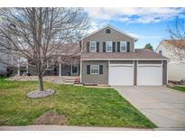 Charming two-story home with a well-manicured lawn and a three-car garage at 5115 E Davies Dr, Centennial, CO 80122