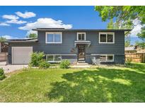 Charming two-story home with dark gray exterior and well-maintained front lawn at 18355 W 59Th Dr, Golden, CO 80403