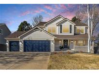 Charming two-story home with a three-car garage, well-manicured lawn, and inviting front porch at 9683 Las Colinas Dr, Lone Tree, CO 80124