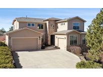 Inviting home with stone accents, a three-car garage, and a well-maintained front yard at 2116 Ridgetrail Dr, Castle Rock, CO 80104