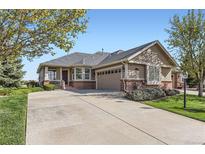 Charming single-story home with a spacious driveway and beautiful landscaping, perfect for comfortable living at 8233 E 149Th Dr, Thornton, CO 80602