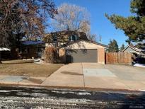 Charming two-story home featuring a spacious two-car garage and a driveway, complemented by a well-maintained front yard at 8727 E Girard Ave, Denver, CO 80231