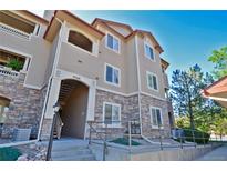 Attractive condo building with brick accents and well-maintained landscaping under a clear sky at 9568 W San Juan Cir # 307, Littleton, CO 80128