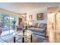 Inviting living room with stylish furniture, glass coffee table, and access to a balcony at 2325 S Linden Ct # 318, Denver, CO 80222