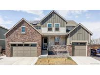 Charming two-story home featuring a stone facade, two-car garage, and inviting front porch at 12965 Grassland St, Longmont, CO 80504