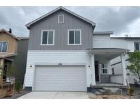 Two-story home featuring a two-car garage, a covered front porch, and two-toned gray and white siding at 2186 Flower Blossom Ave, Brighton, CO 80601