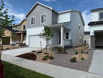 Charming two-story home featuring a gray and white exterior, a well-manicured lawn, and a two car garage at 2186 Flower Blossom Ave, Brighton, CO 80601