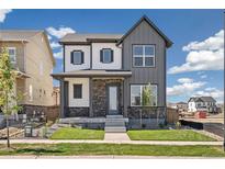 Attractive two-story home featuring a stone facade, covered porch, and well-maintained lawn at 21022 E 63 Dr, Aurora, CO 80019