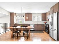 A charming kitchen featuring a stainless steel refrigerator, and a wooden table with seating at 16012 E Floyd Ave, Aurora, CO 80013
