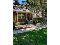 Charming brick home with a inviting front entrance and lush landscaping, featuring a 'For Sale' sign at 7721 S Curtice Way # B, Littleton, CO 80120