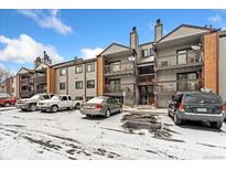 Apartment complex with balconies and parking lot dusted with snow at 6350 Oak St # 103, Arvada, CO 80004