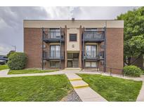 Brick apartment building featuring black iron balconies and landscaped front yard at 5995 W Hampden Ave # 2G, Denver, CO 80227