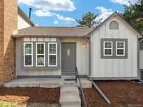 Charming home featuring neutral siding, multiple windows, and steps up to a dark gray front door at 16986 E Piedmont Dr # A, Aurora, CO 80015