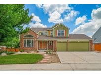 Inviting two-story home with a brick facade, lush lawn, and a three car attached garage at 2882 Signal Creek Dr, Thornton, CO 80241