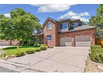 Charming brick two-story home with a manicured lawn and a two-car garage on a sunny day at 6429 S Jamaica Cir, Englewood, CO 80111