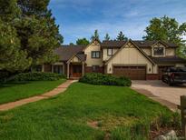 Charming home featuring a manicured lawn, mature trees, and an attached two car garage at 15395 E Penwood Pl, Aurora, CO 80015