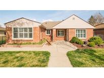 Charming brick home featuring a well-manicured lawn, inviting walkway, and pleasant curb appeal at 2972 Kearney St, Denver, CO 80207