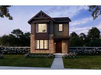 Charming two-story home featuring stone accents, a covered entryway, and a well-manicured front lawn at 7241 Goldbloom Ln, Littleton, CO 80125