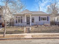 Charming home with landscaped front yard and black iron fence at 5920 S Bemis St, Littleton, CO 80120