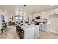 Bright kitchen with large island, quartz countertops, stainless appliances, and open-concept to the living area at 128 E Douglas St, Superior, CO 80027