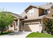 Inviting two-story home featuring a two-car garage, well-maintained lawn, and a charming covered front porch at 9481 Longstone Dr, Parker, CO 80134